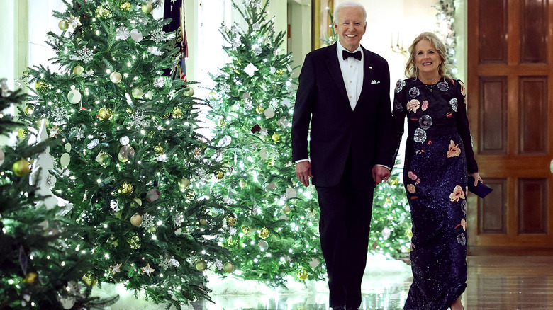 Joe and Jill Biden walking past Christmas trees