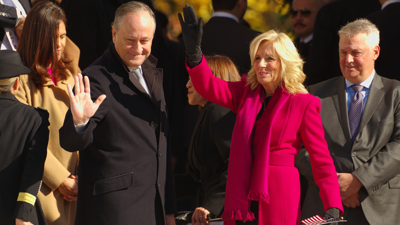 Jill Biden wearing red, waving with Doug Emhoff