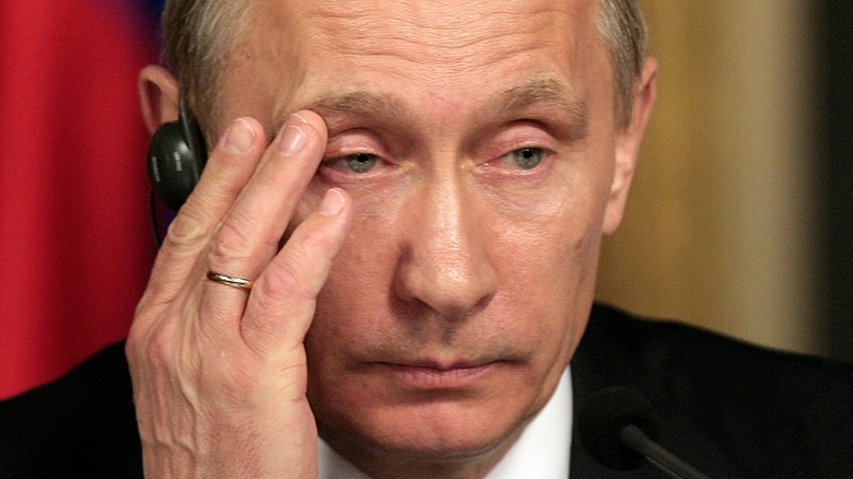 Vladimir Putin looking fed-up head in hand