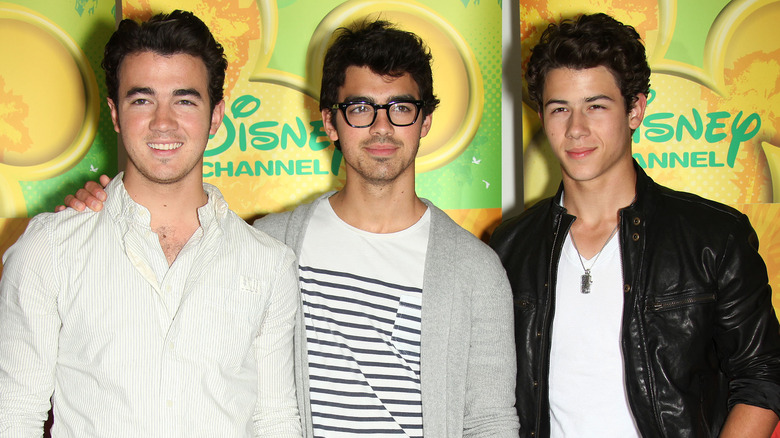 Jonas Brothers posing together at Disney event