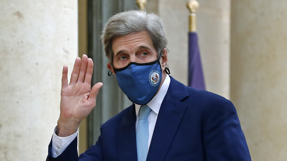 John Kerry waving, wearing a mask