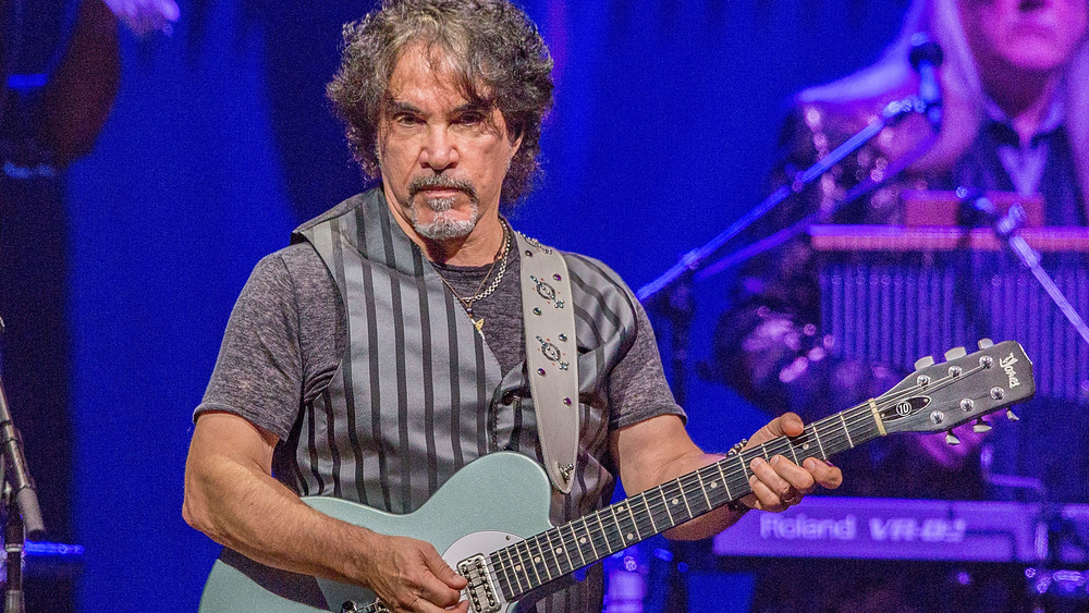 Hall & Oates guitarist John Oates looking stern, playing guitar 