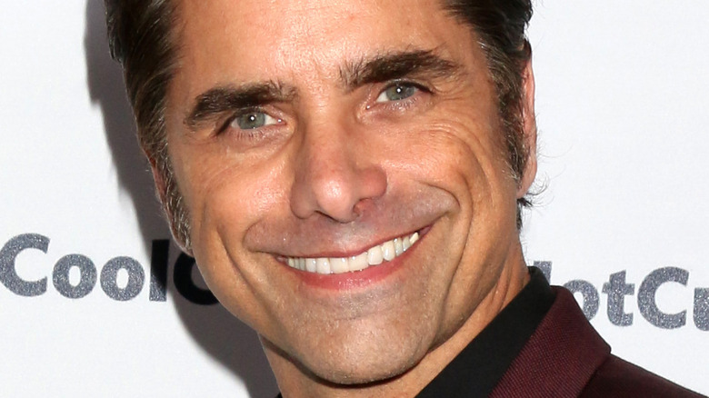 John Stamos smiles in burgundy suit