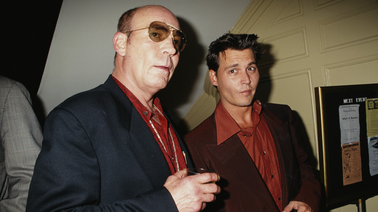 Author Hunter S. Thompson wearing a black jacket and red shirt with Johnny Depp wearing a brown jacket and burnt orange shirt