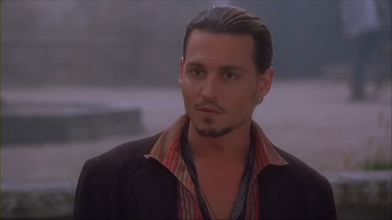 Johnny Depp wearing a brown jacket and red and brown striped collared shirt