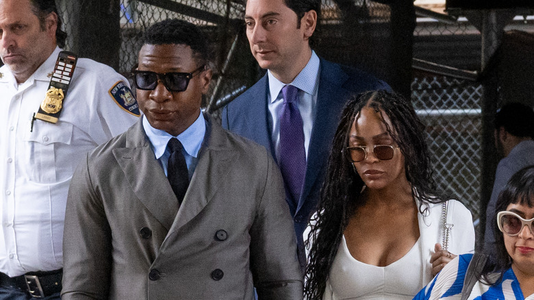 Jonathan Majors and Meagan Good walking from court together