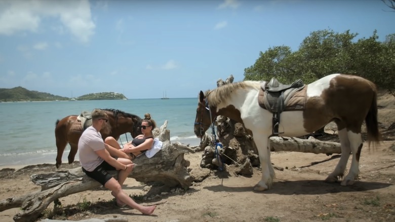 Adam Aveling and Tayah Victoria sitting on the beach with horses on Married at First Sight UK