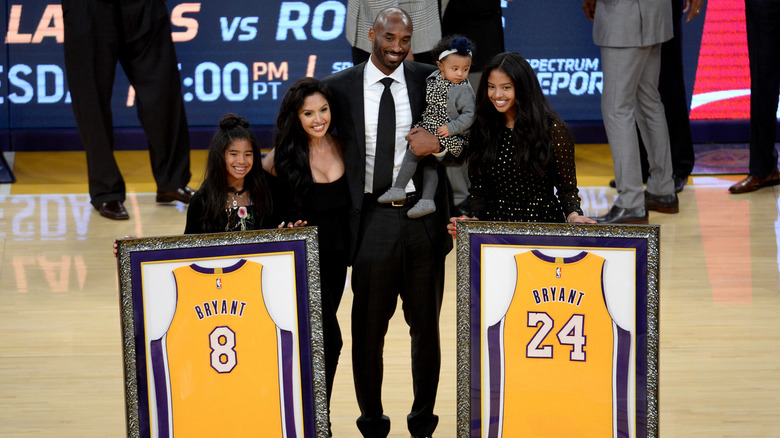 Kobe Bryant and family posing for a picture with jerseys