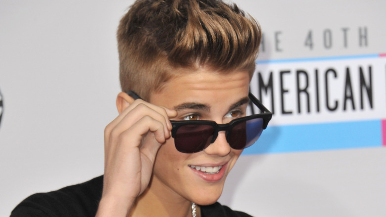 Justin Bieber lifting sunglasses