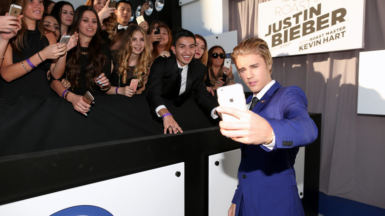 Justin Bieber taking selfie with fans