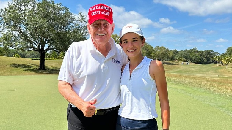 Donald Trump on a golf course with granddaughter Kai Trump