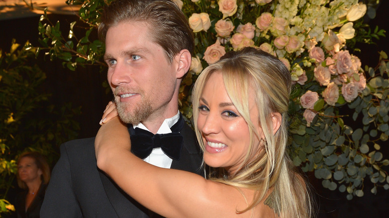 Kaley Cuoco with arms around Karl Cook's neck