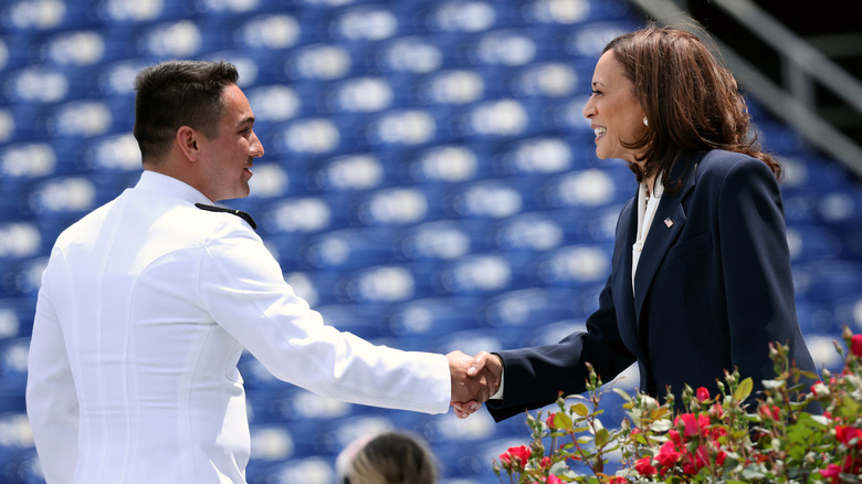 Kamala Harris shaking hands with a Naval Academy graduate