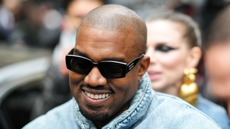 Kanye West laughing, Julia Fox in background