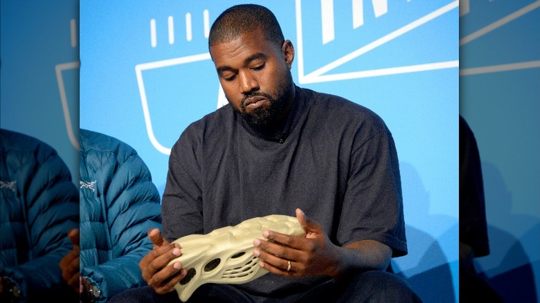 Kanye West looking sadly at shoe