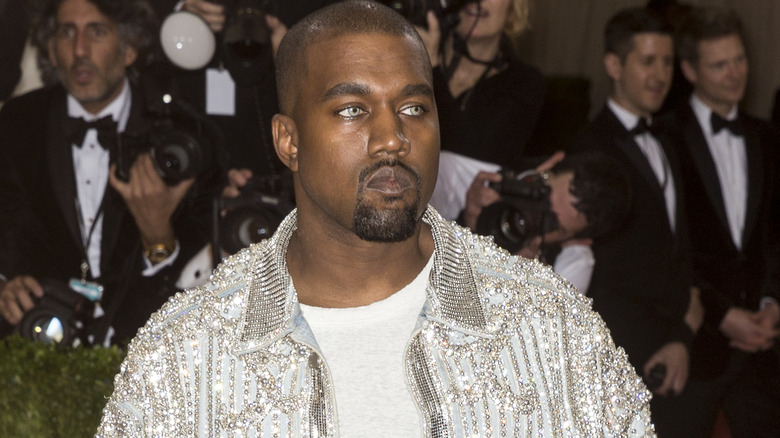 Kanye Wests stares into cameras on the red carpet