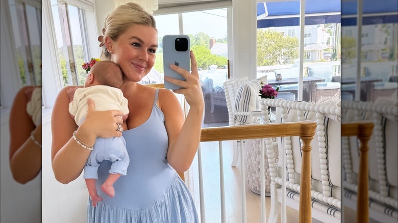 Karoline Leavitt wearing a blue dress holding baby