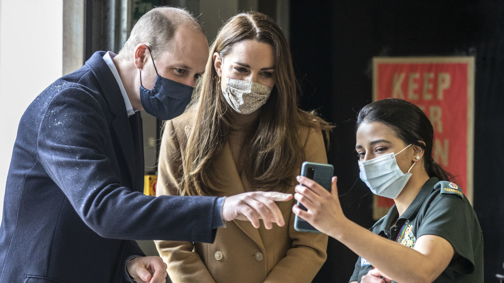 Prince William and Kate Middleton speaking with a paramedic