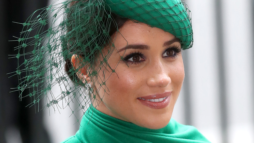 Meghan Markle smiling in green