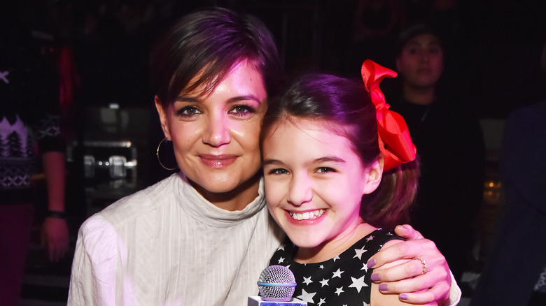 Katie Holmes with arm around Suri Cruise