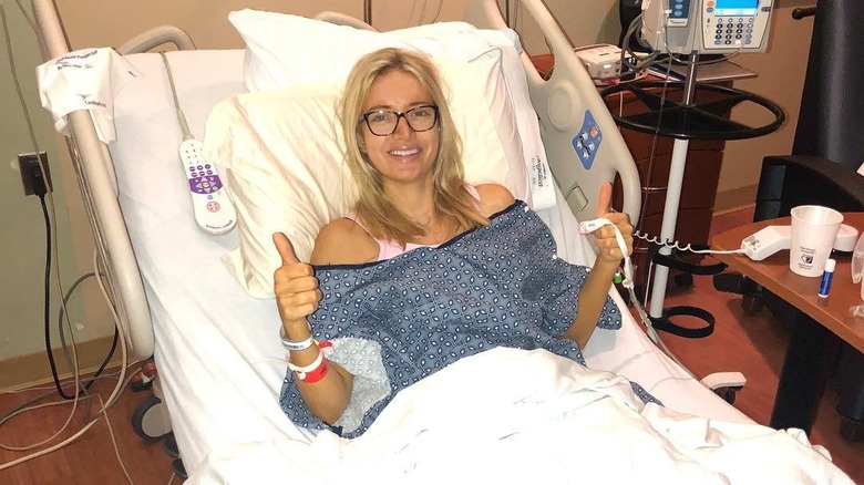 Kayleigh McEnany smiling with thumbs up on a hospital bed