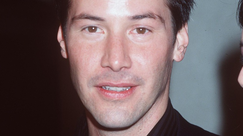 Keanu Reeves with short hair, posing