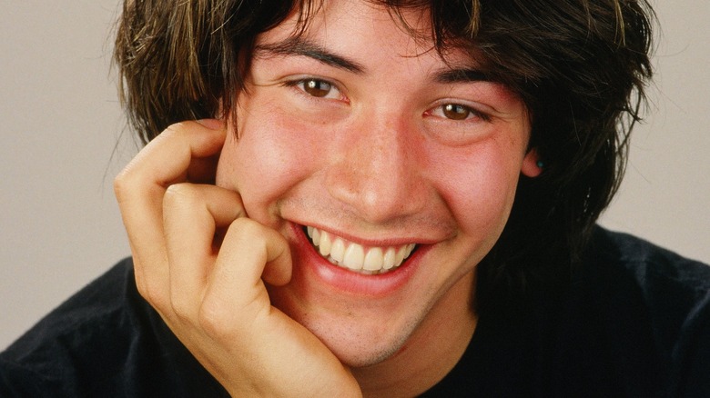 Keanu Reeves poses for a portrait, smiling