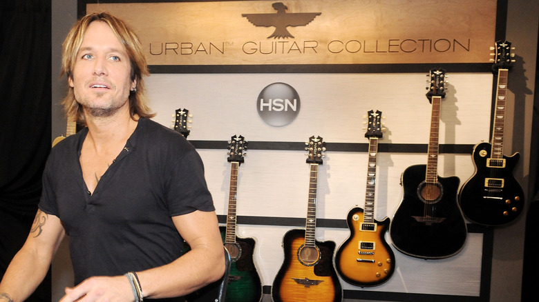 Keith Urban standing with his guitar collection