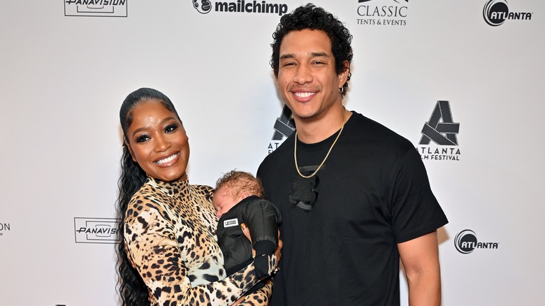 Keke Palmer and Darius Jackson posing with baby