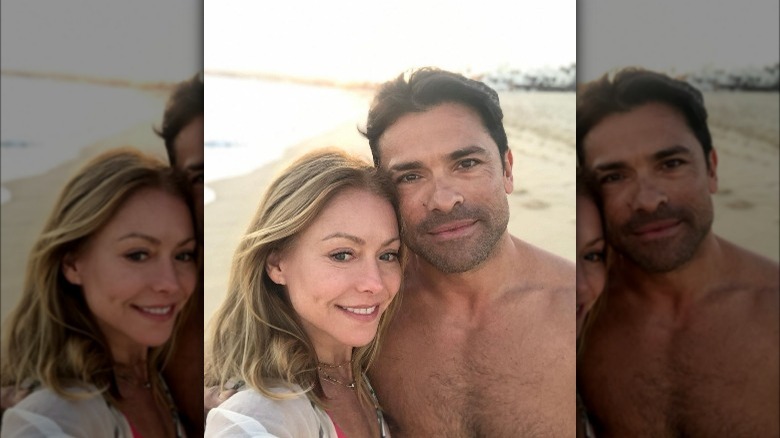 Kelly Ripa cuddling Mark Consuelos at the beach