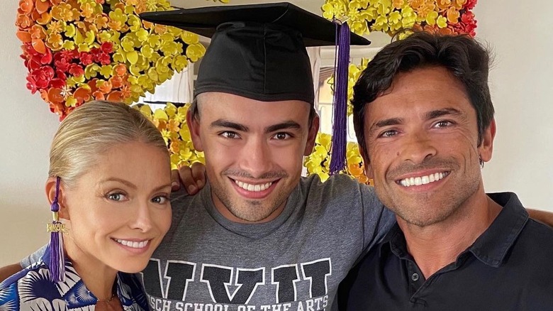 Michael Consuelos wearing graduation cap with parents