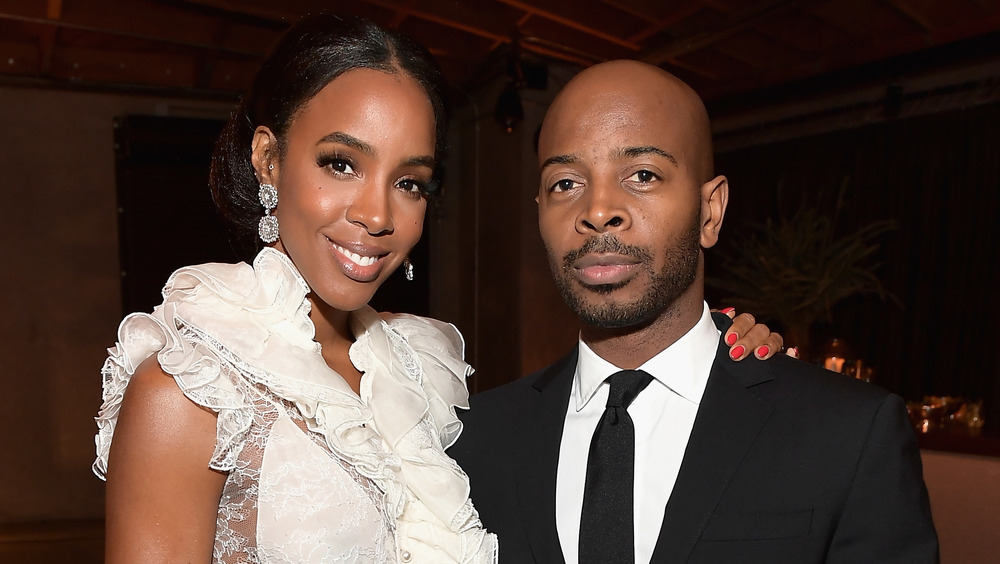 Kelly Rowland and Tim Weatherspoon posing at an event