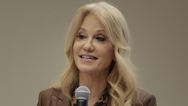 Kellyanne Conway holding a mic at a meeting