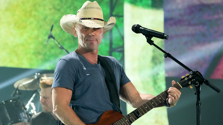 Kenny Chesney plays guitar at concert