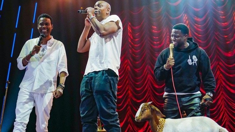 Chris Rock, Dave Chappelle, and Kevin Hart on stage with a goat