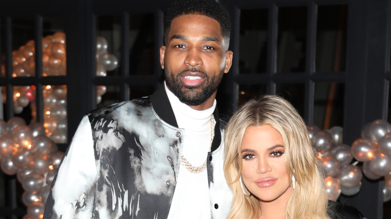 Tristan Thompson and Khloe Kardashian pose together at a party