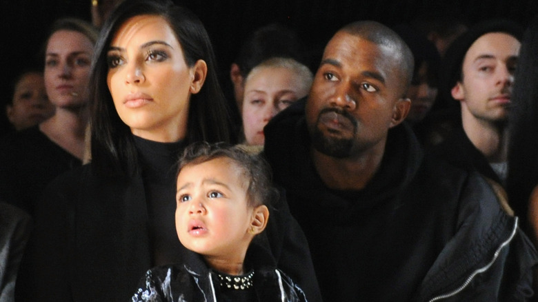 Kim Kardashian, Kanye West, and North watching a game