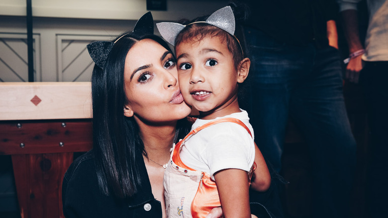 Kim Kardashian and her daughter posing