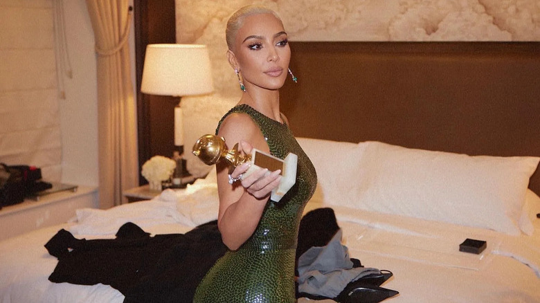 Kim Kardashian in green dress holding Golden Globe