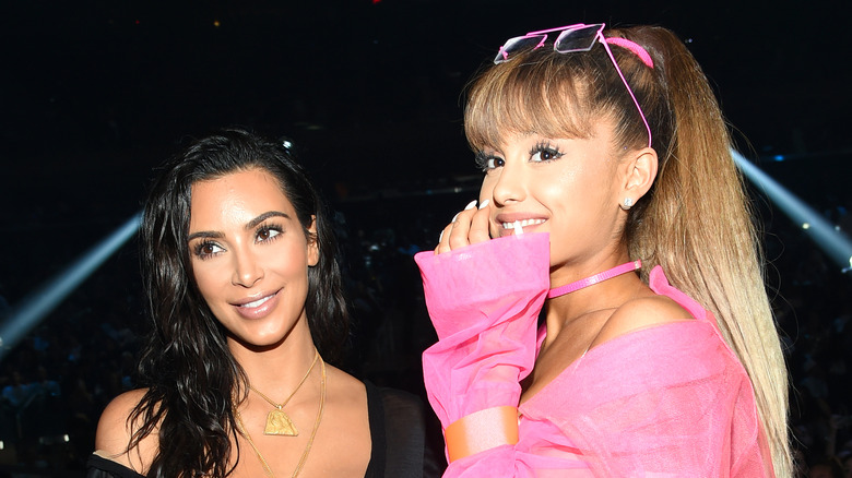 Kim Kardashian laughing with Ariana Grande in 2018