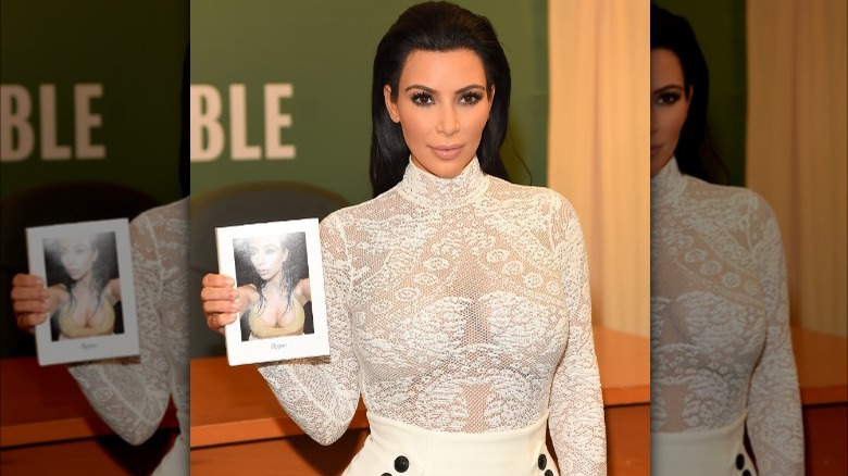 Kim Kardashian holding Selfish book