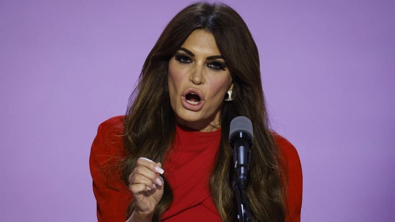 Kimberly Guilfoyle wearing a red dress on stage with her mouth open