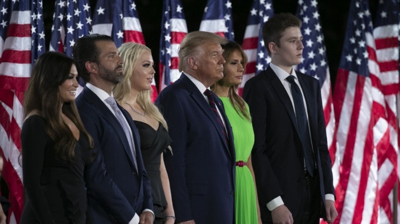 Kimberly Guilfoyle stands on stage with Trump family