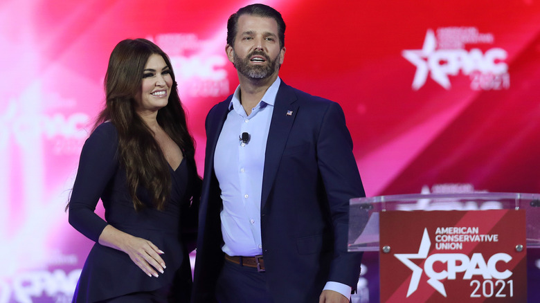 Kimberly Guilfoyle with Don Jr. at a podium