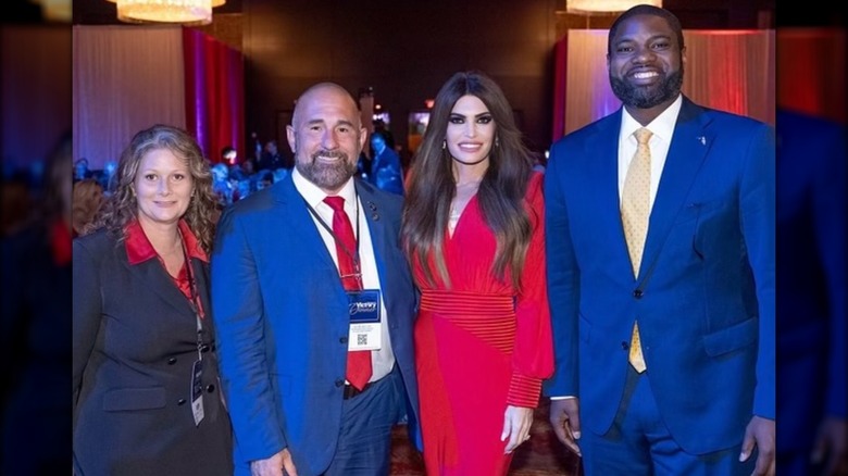 Kimberly Guilfoyle wearing a red dress and posing with attendees at the Florida GOP's Victory Dinner