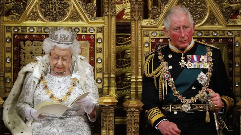 Queen Elizabeth II, King Charles III on gold thrones