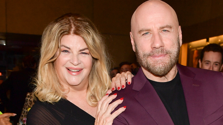 Kirstie Alley smiles with her hands on John Travolta's shoulder