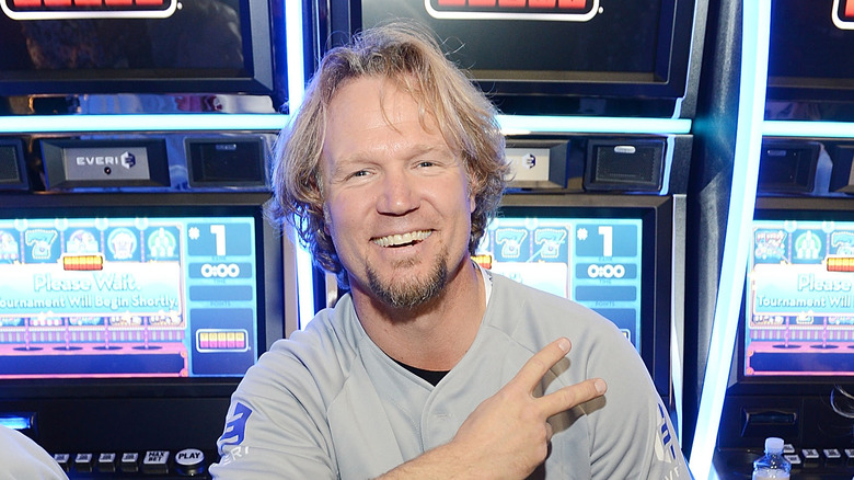 Kody Brown posing in front of casino slot machines