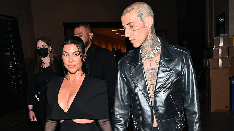 Kourtney Kardashian and Travis Barker walk