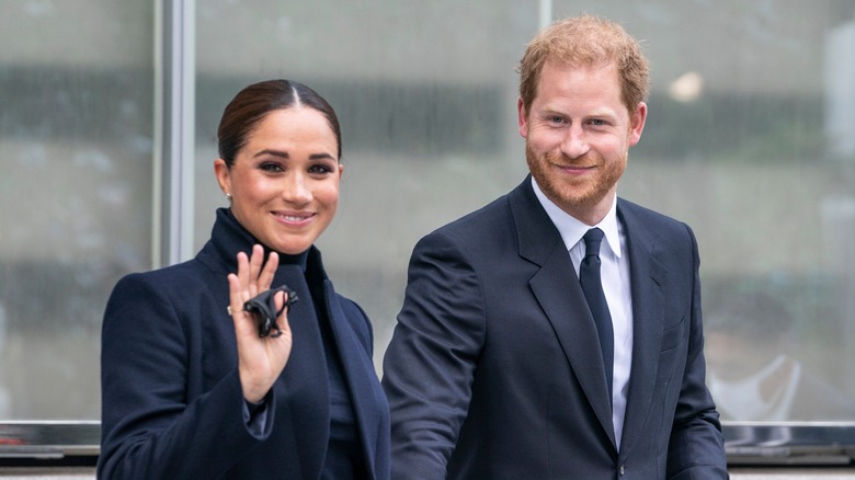 Prince Harry and Meghan Markle smile and wave